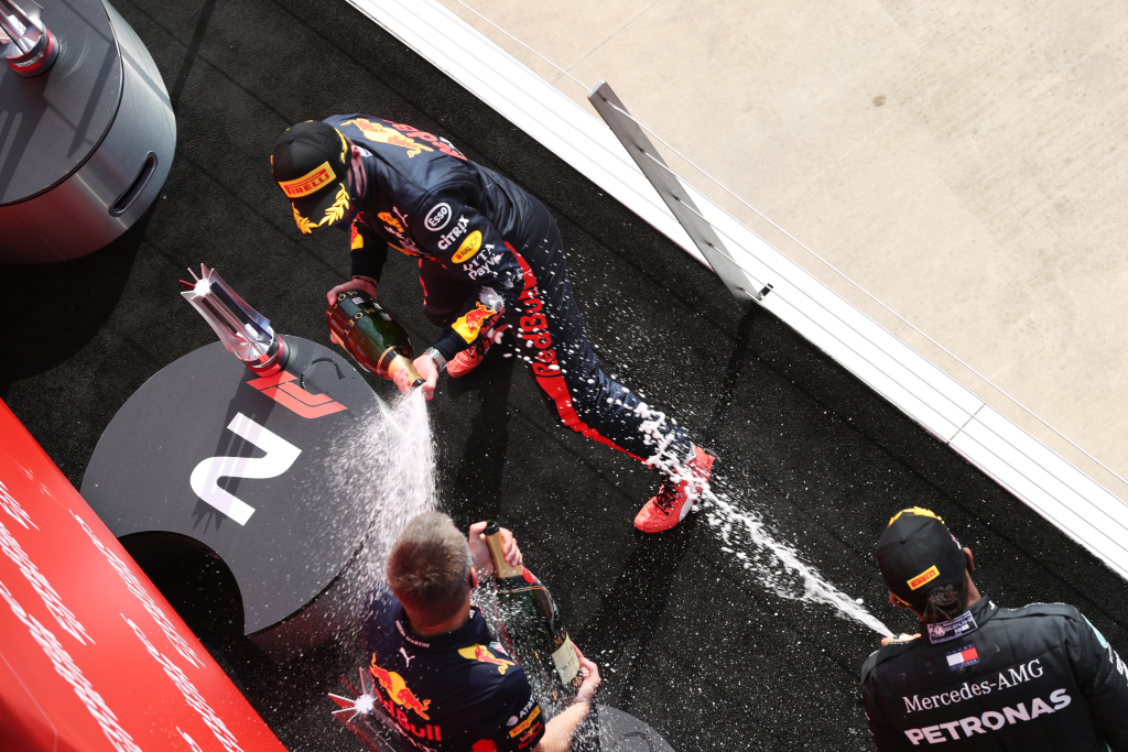 F1 drivers celebrate on the podium by spraying champagne