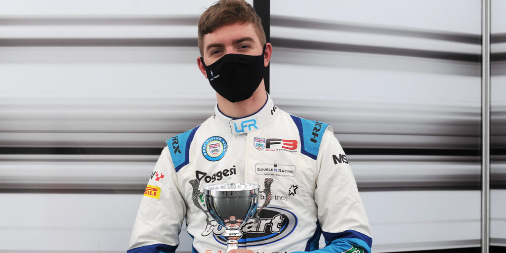 Racing driver Louis Foster holds a trophy