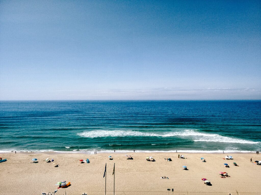 People sunbathing on a beach in Portugal.