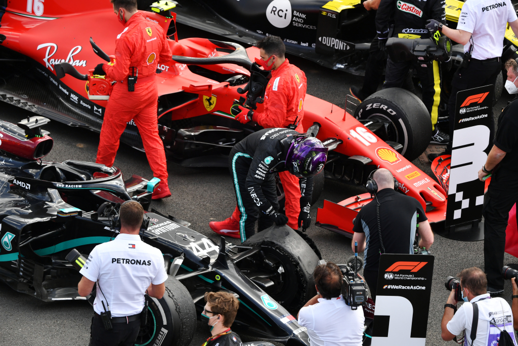 Lewis Hamilton inspects the punctured tyre of his F1 car