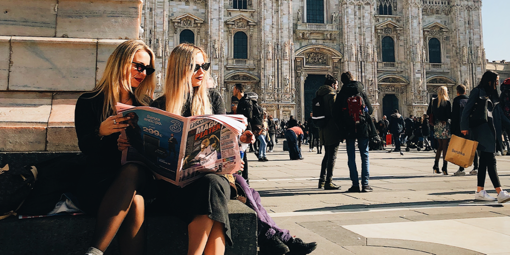 Two people reading a newspaper at the PIazza del Duomo
