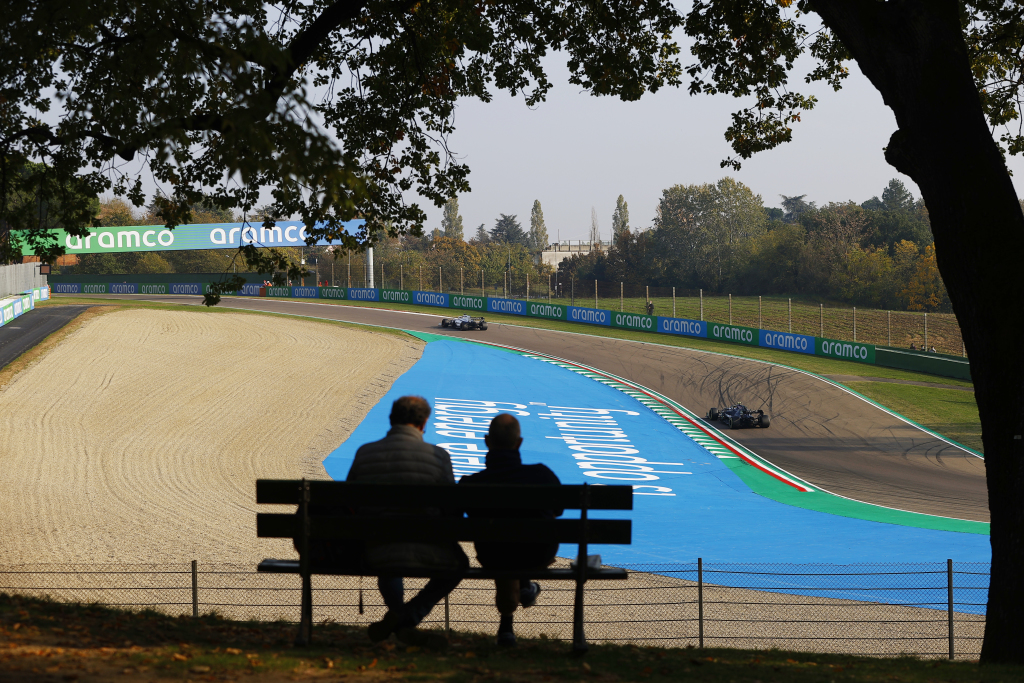 Two fans watch a Formula 1 race on a bench