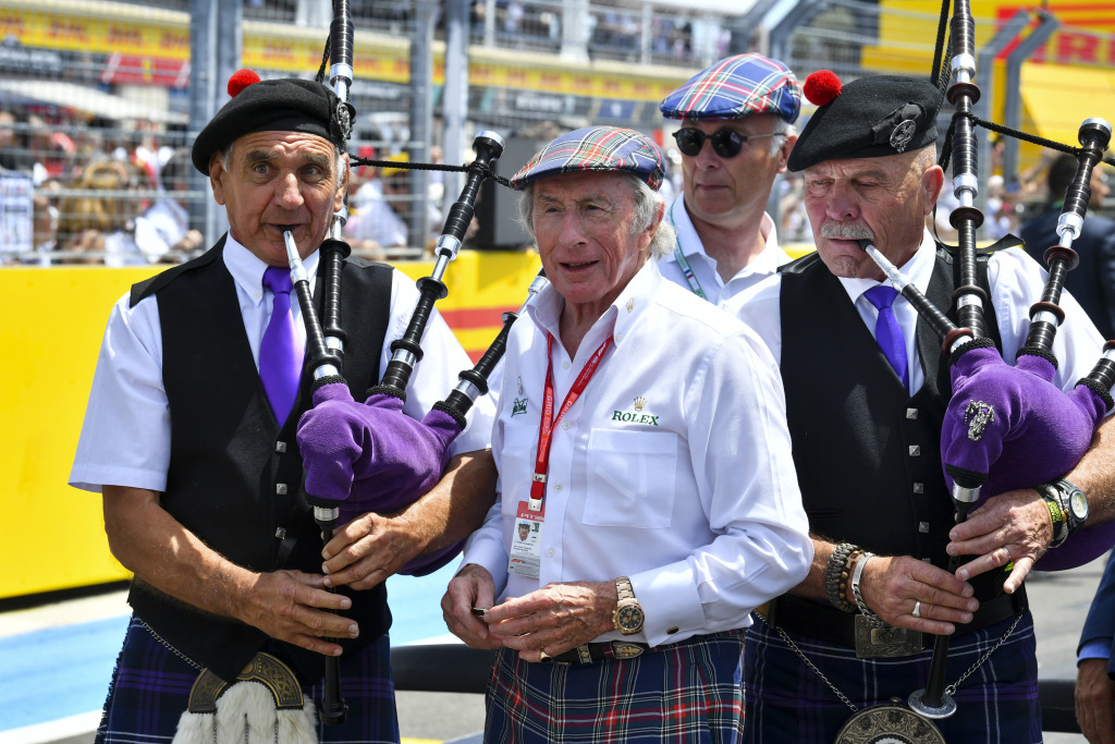Jackie Stewart flanked by bag pipe players