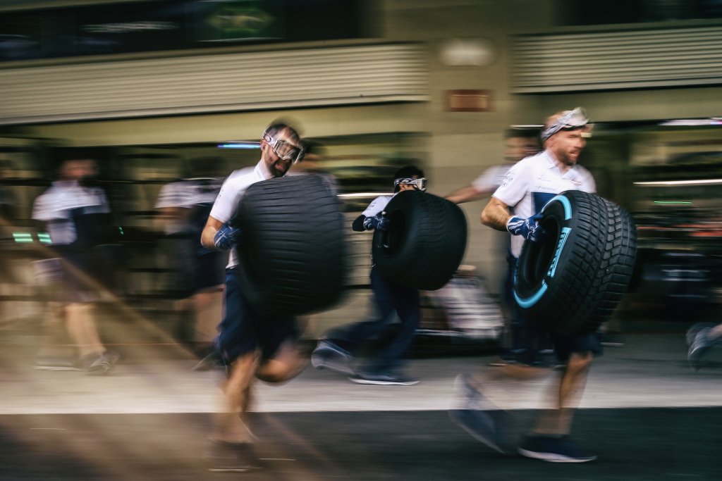 Mechanics running with Formula 1 tyres