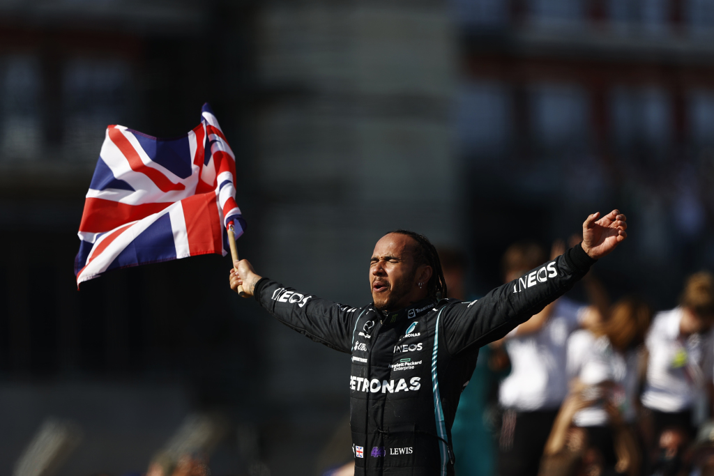 On of the greatest Formula 1 drivers Lewis Hamilton waving a British flag.