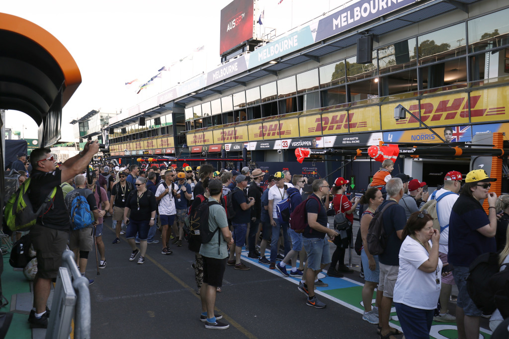 Fans walking a pit-lane and taking photographs