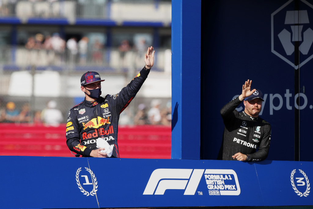 Max Verstappen and Valtteri Bottas wave during the Sprint race victory lap