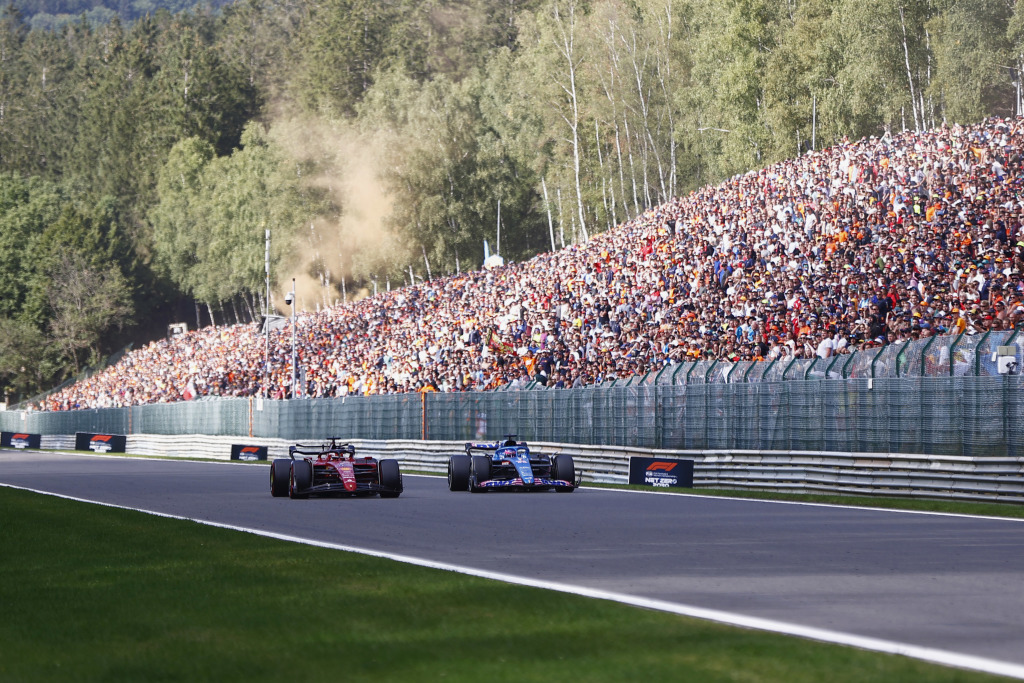 Charles Leclerc and Fernando Alonso driving along the Kemmel Straight in Belgium in front of thousands of fans.