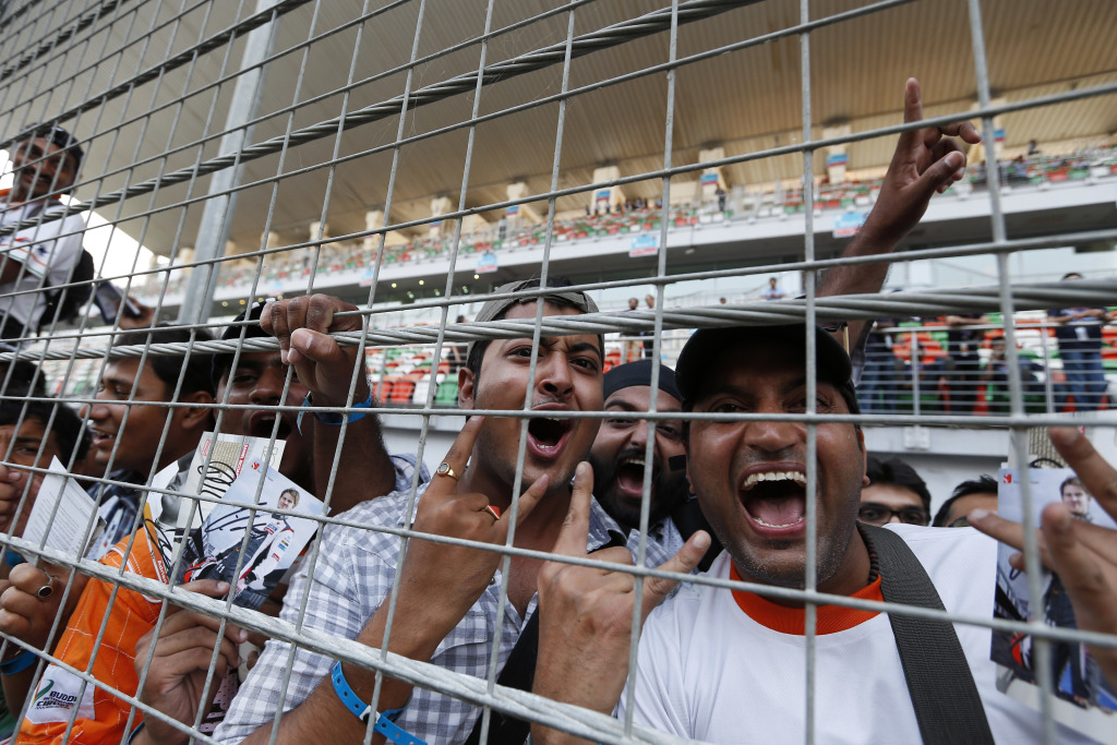 Fans celebrating behind a catch fence during the Indian Grand Prix