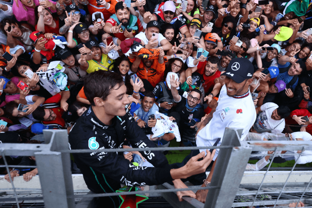 Lewis Hamilton and George Russel take a selfie with packed grandstands