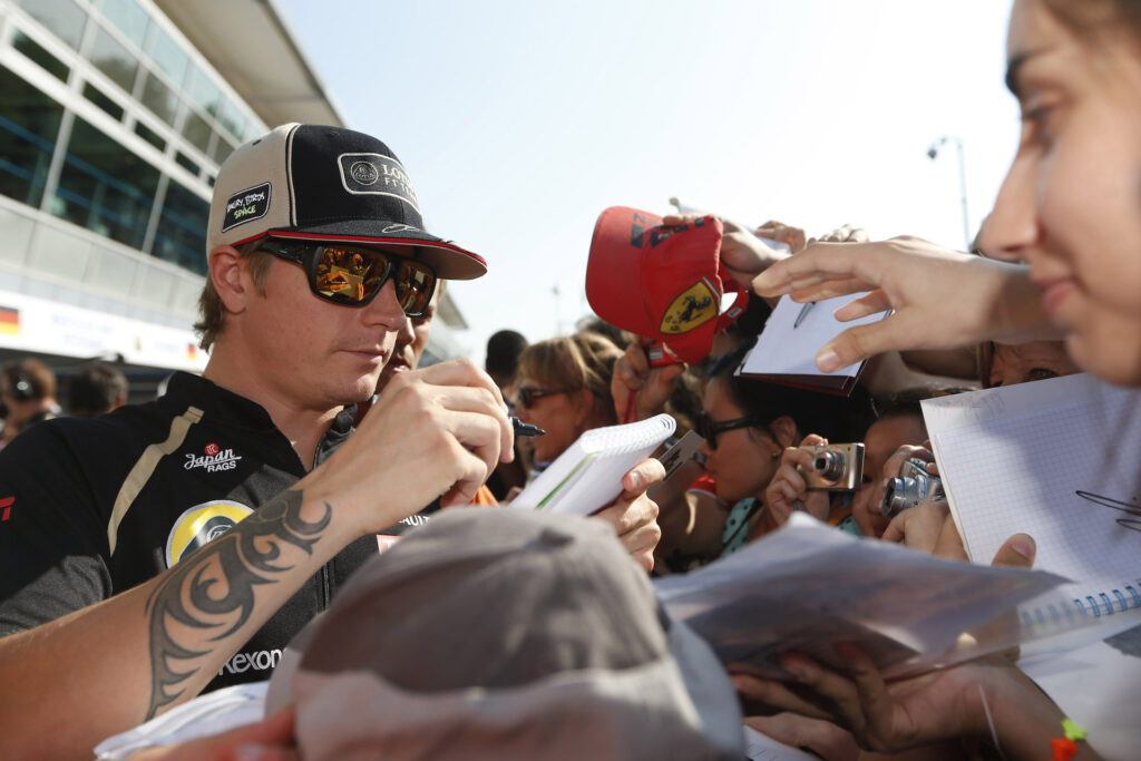 Kimi Raikkonen signs autographs for fans at Monza in September 2012.